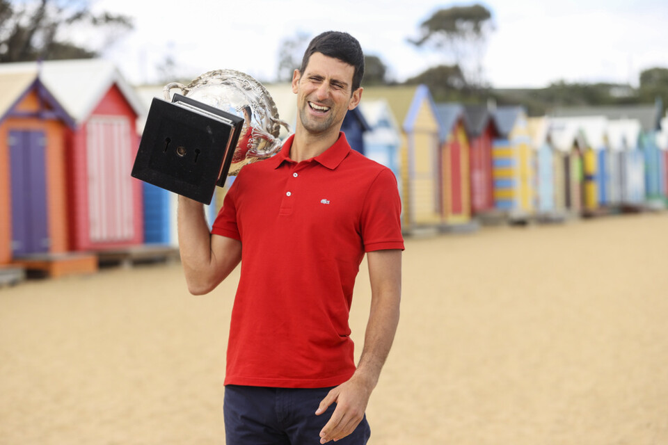 Novak Djokovic med sin senaste Australian Open-pokal på stranden i Melbourne i januari i år.
