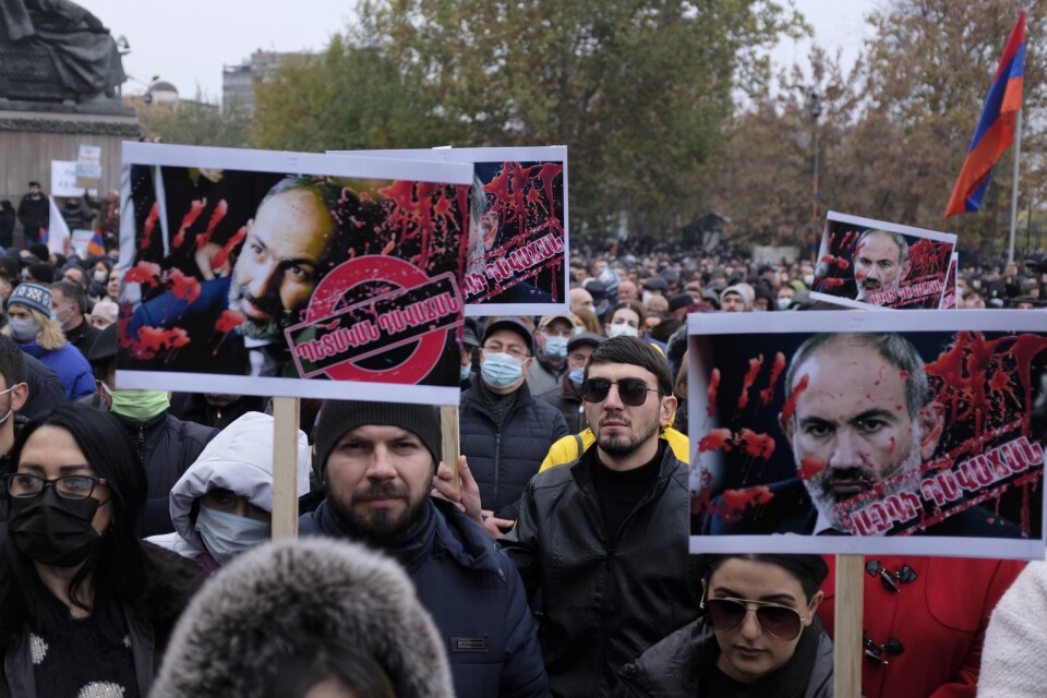 Demonstranter i Armeniens huvudstad Jerevan bär plakat där premiärminister Nikol Pasjinian framställs som blodbesudlad.
