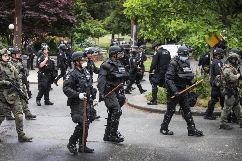 Skyddsutrustade poliser i Seattle avlägsnar folk från Cal Anderson-parken på onsdagen.