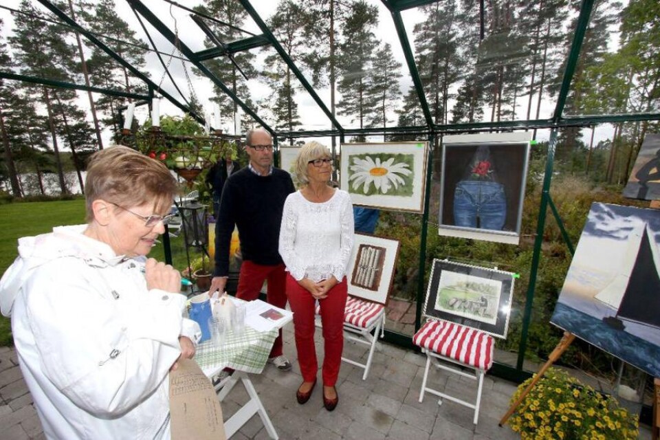 Barbro Sonnhag tittar på målningar i Richard och Ann Svenssons växthus.