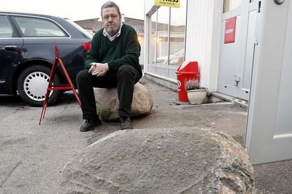 "Det här försvårar för dem i varje fall", säger Ulf Holmkvist om de stora stenar han placerat framför entrén till butiken. Den 17 juli forcerade en bil entrén. Bild: Claes Nyberg