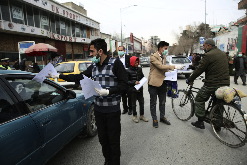 Aktivister delar ut informationsblad om coronaviruset till människor i Afghanistans huvudstad Kabul.