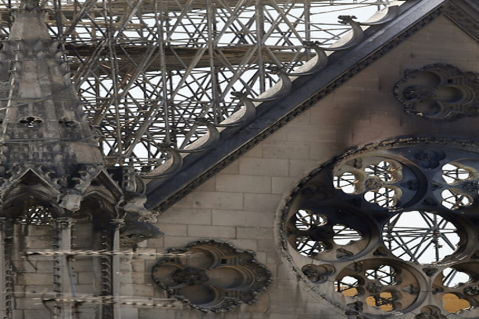 En man kontrollerar den bärande träkonstruktionen i Notre-Damekyrkan efter branden.