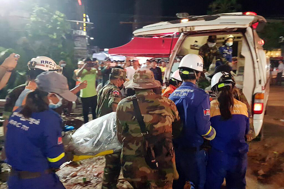 Räddningsarbetare lyfter in ett av offren i en ambulans.
