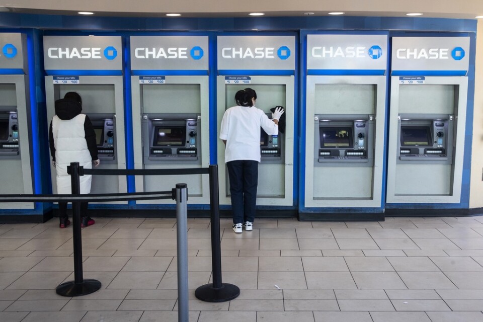 En bankanställd desinficerar bankomater i Queens.