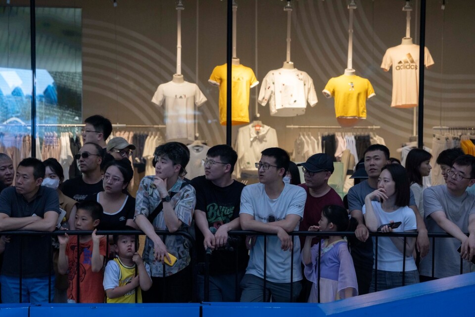 Människor utanför ett shoppingcenter i Peking. Arkivbild.