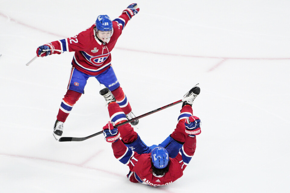 Montreals Josh Anderson firar liggandes på isen att han just avgjort den fjärde finalmatchen i Stanley Cup. Lagkamraten Cole Caufield skyndar fram för en segerkram.