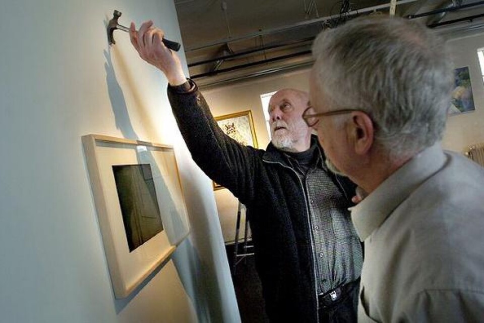 Lennart Smidfelt och Björn Flygare mäter och diskuterar vid en av Håkan Bergs bilder. Bild: Bosse Nilsson