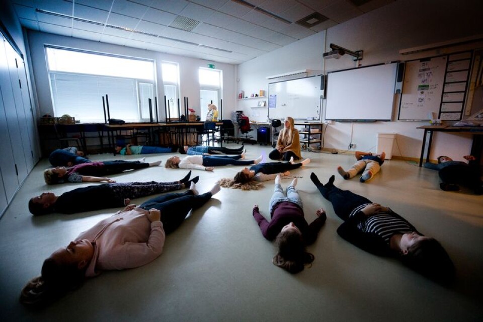 Lina Ahlqvist, leder rörelsemeditationen och uppmanar eleverna att känna sig tunga – och lätta.