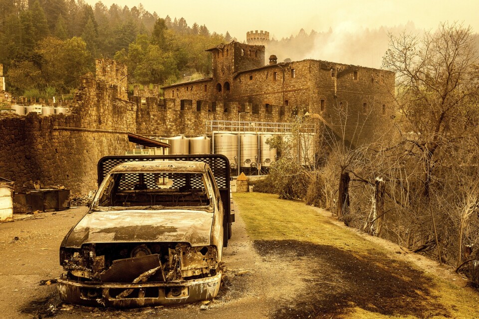 Ett utbrunnet fordon framför vinproducenten Castello di Amorosa.