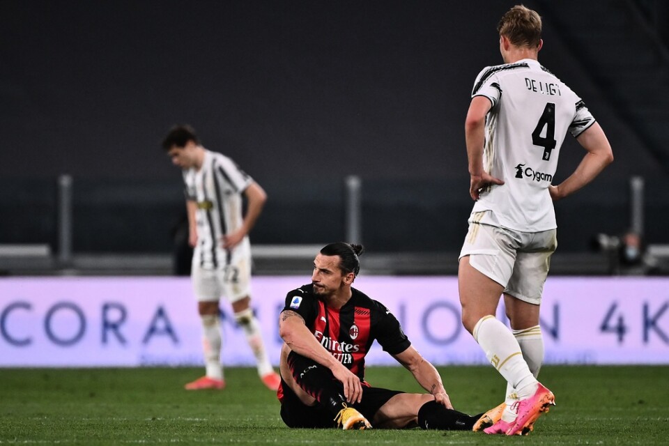 Zlatan Ibrahimovic sitter i gräset och tar sig för sitt vänstra knä.