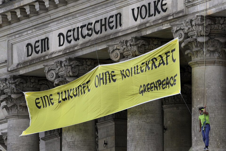 Miljöaktivister från Greenpeace förlängde på fredagen det tyska mottot "Dem deutschen Volke" i Berlin med sin slogan "Eine Zukunft ohne Kohlekraft" – vilket sammantaget kan översättas, "En framtid utan kolenergi för det tyska folket".