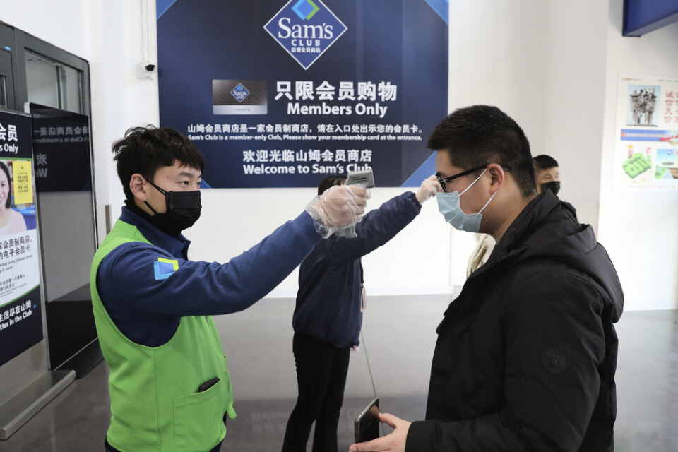 En anställd kontrollerar temperaturen på en kund i entrén till Sam's Club i Nantong i provinsen Jiangsu i Kina. Bild tagen 1 februari.