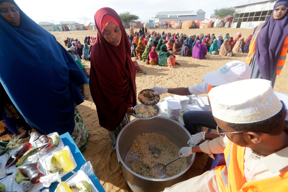 Lokala hjälporganisationer förbereder mat åt invånarna i ett läger för internflyktingar i utkanten av Mogadishu, Somalia, i mars. Arkivbild.