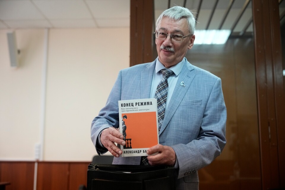 Oleg Orlov, medordförande i Memorials styrelse, visar upp en bok om auktoritära regimers fall i rättssalen i Moskva. Bilden togs den 8 juni.
