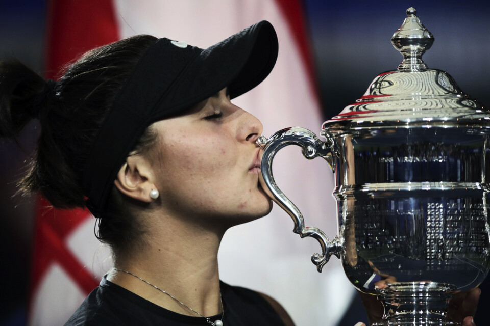Bianca Andreescu kysser segerpokalen efter vinsten i US Open. I bakgrunden den kanadensiska flaggan.