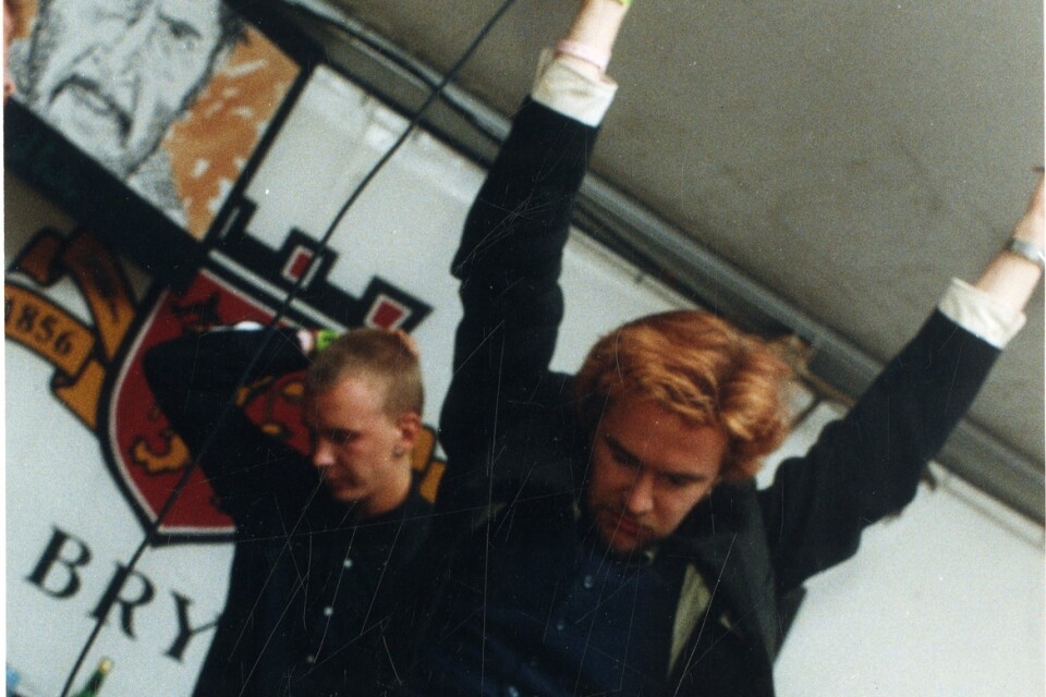 En raritetbild från Kents mytomspunna öltältsspelning i Hultsfred 1994. Jokce Berg hoppar på bilden. Dåvarande Kent-gitarristen Martin Roos berättar i podden.