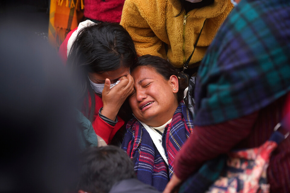 En kvinna gråter när kvarlevorna efter hennes släkting anländer till ett sjukhus i Pokhara efter söndagens flygkrasch.
