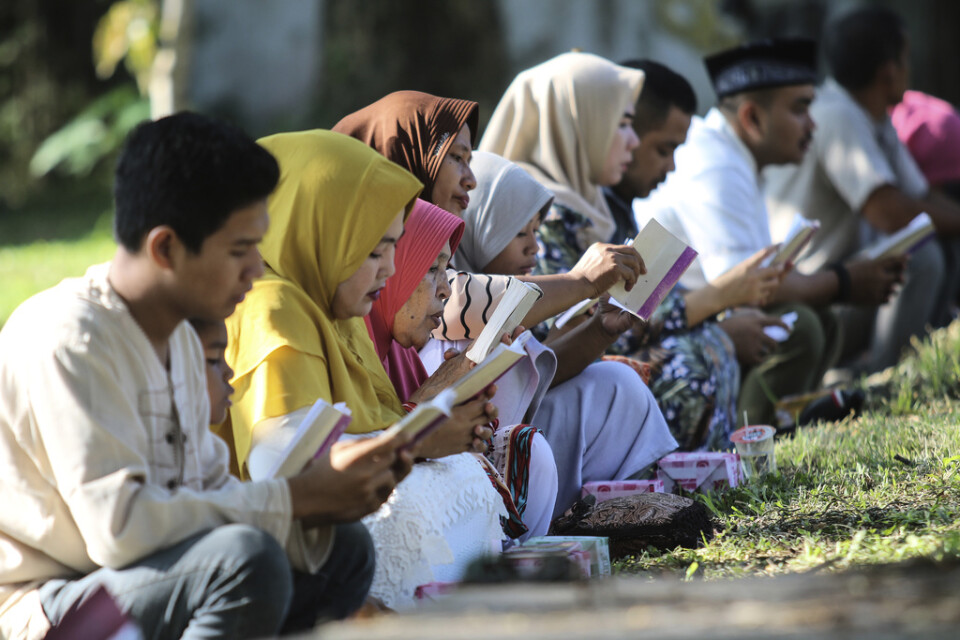 Sörjande ber vid en gravplats för tsunamioffren i Banda Aceh i Indonesien under torsdagen.