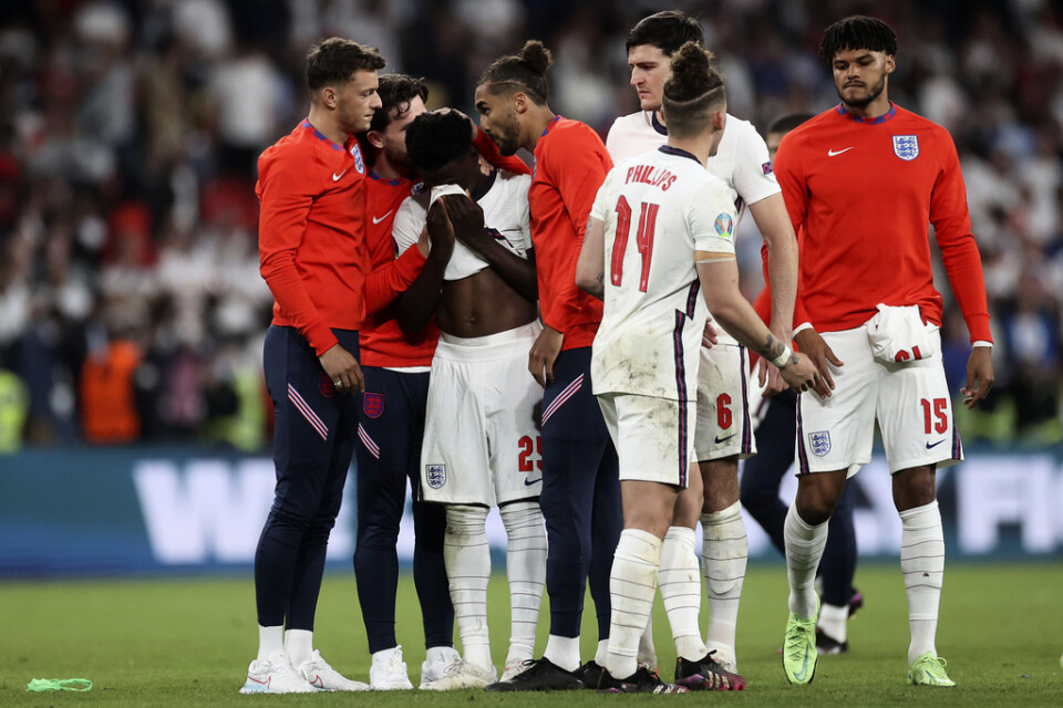 De engelska spelarna försöker trösta sin lagkamrat Bukayo Saka efter straffmissen.