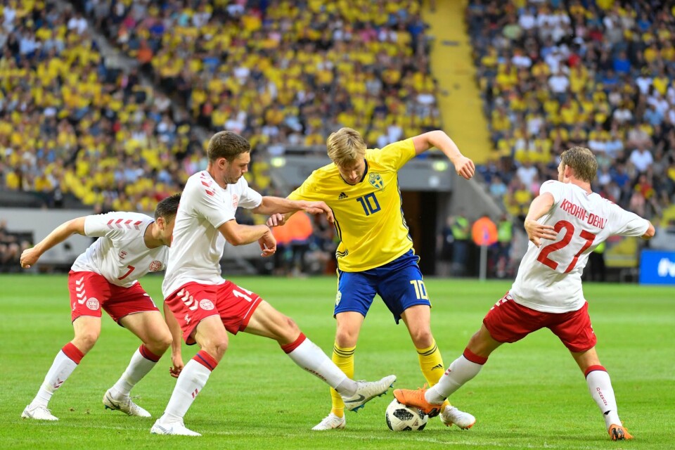 Sveriges Emil Forsberg uppvaktad frånb två håll under lördagens landskamp i fotboll mellan Sverige och Danmark på Friends Arena.