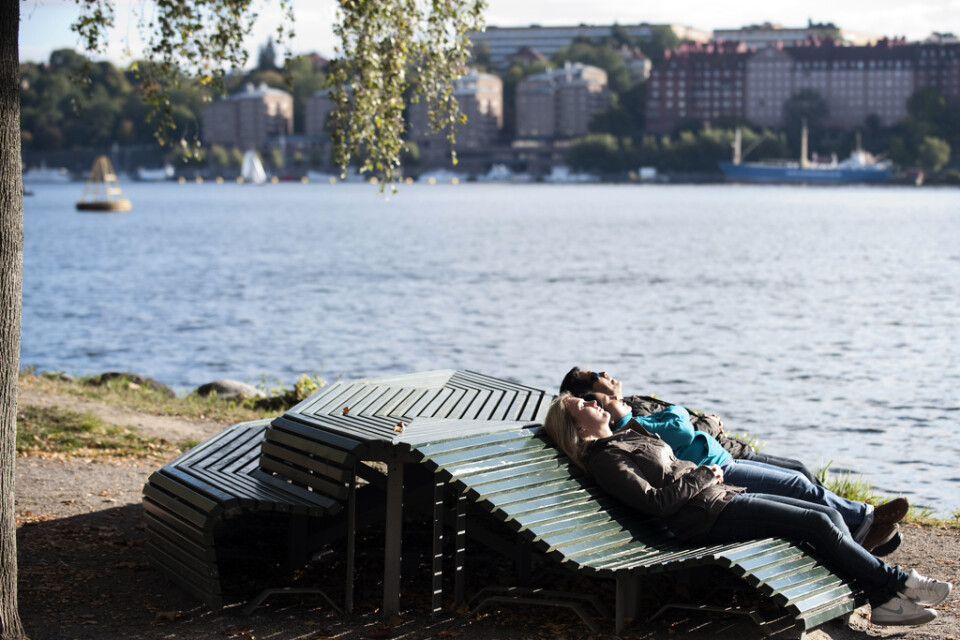 Solande människor vid Norr Mälarstrand i Stockholm. Arkivbild från i oktober..