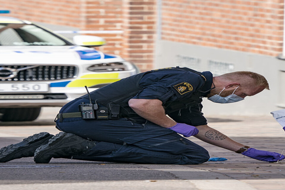 Polisens kriminaltekniker i arbete på den trottoar i centrala Helsingborg där en kvinna utsattes för ett knivdåd.