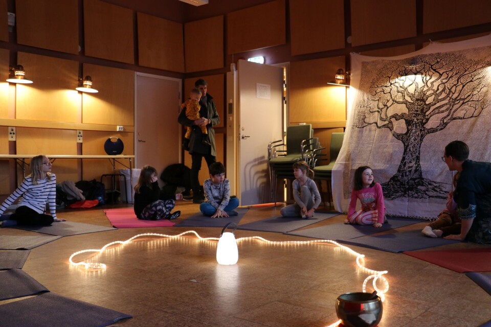 En efter en samlades barnen på var sin yogamatta inför sagoyogan. Ljus och tyger gjorde rummet mysigt.