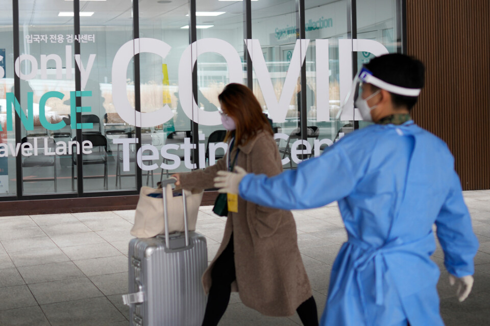 En kvinna som anländer till Sydkorea från Kina blir visad till en plats där hon kan covidtestas på flygplatsen. Arkivbild.