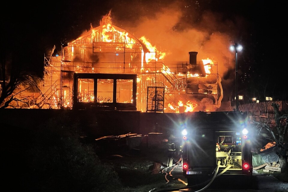 En större villa på Ekerö totalförstördes i en brand under fredagskvällen. Räddningstjänsten arbetar för att rädda närliggande fastigheter.