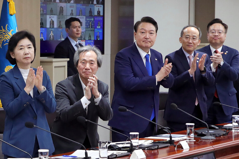 Sydkoreas president Yoon Suk-Yeol (i mitten) applåderar landets vårdarbetare under den sammankomst där de slopade restriktionerna meddelades.