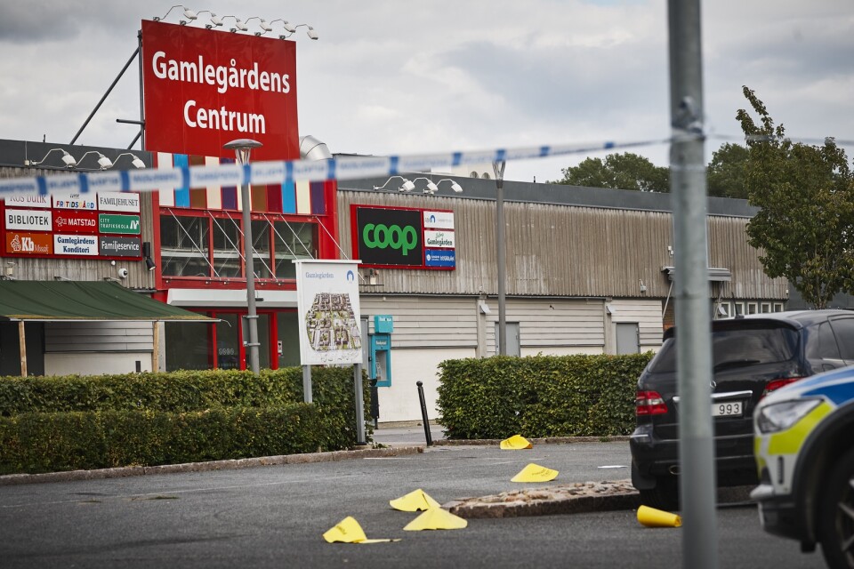Strax efter skottlossningen vid Gamlegårdens Centrum. Polisen har märkt ut fynd som gjorts på parkeringsplatsen med gula koner.