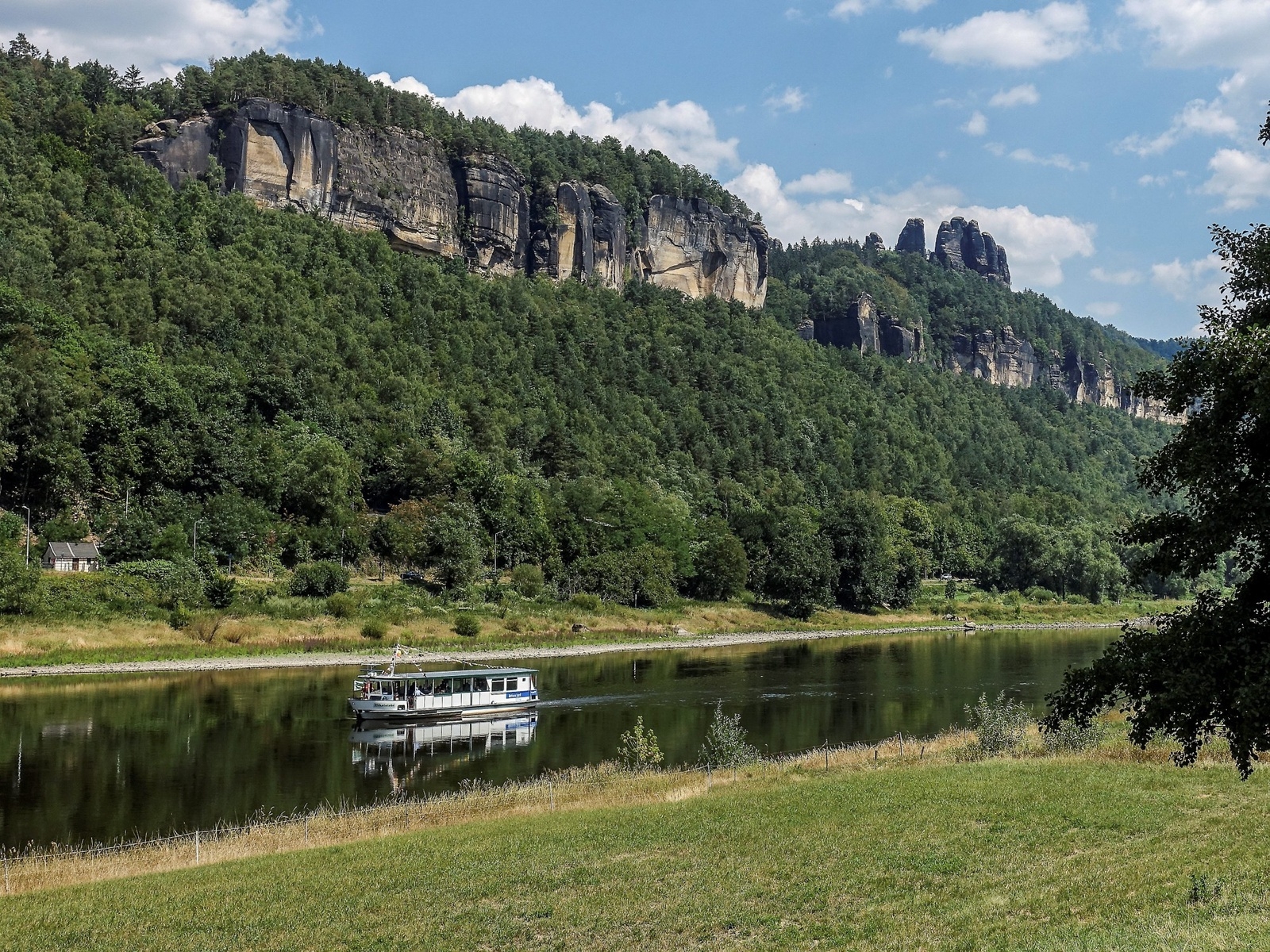 Det är lätt för vandrare att korsa floden Elbe, här finns gott om färjor och båtar. I bakgrunden syns några av Schrammsteines imponerande klippor.
Foto: Kerstin Krafft