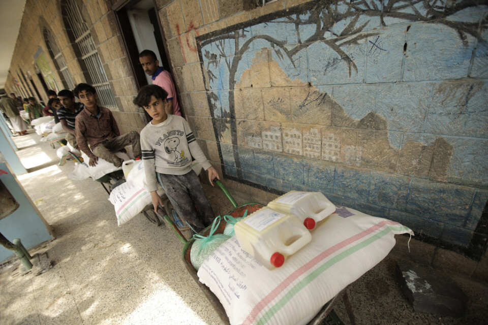 Barn som tvingats flytta hämtar mat från Världshälsoorganisationen (WHO) i staden Sana i Jemen. Arkivbild.