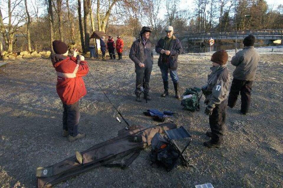 Roger Olsson och Sven Olsson instruerar några av de första tappra fiskarna på nyårsdagens morgon.