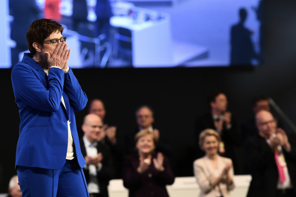 CDU-ledaren Annegret Kramp-Karrenbauer på partikongressen, med en applåderande Angela Merkel i bakgrunden.