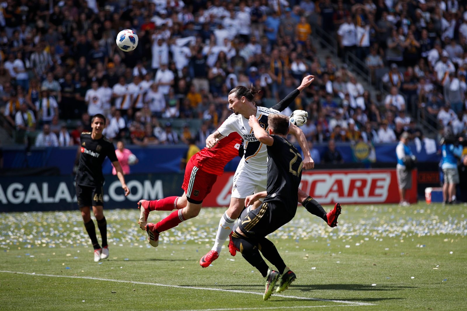 Los Angeles Galaxy's Zlatan Ibrahimovic, center, of Sweden, heads the ball for a goal, his second goal of the game, against Los Angeles FC goalkeeper Tyler Miller during the second half of an MLS soccer match Saturday, March 31, 2018, in Carson, Calif. The Galaxy won 4-3. (AP Photo/Jae C. Hong)