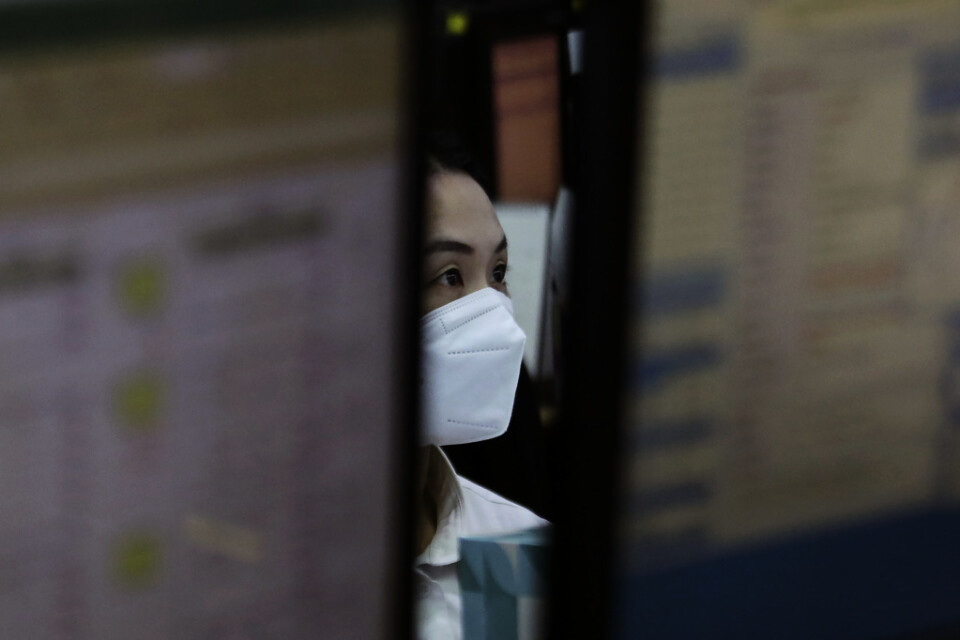En valutahandlare på KEB Hana Ban i Seoul, Sydkorea, har på sig munskydd på jobbet.