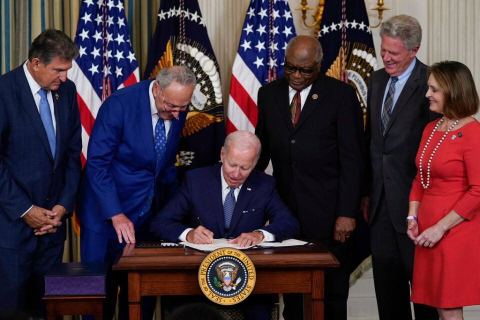 USA:s president (i mitten) när han undertecknar den nya lagen på tisdagen.