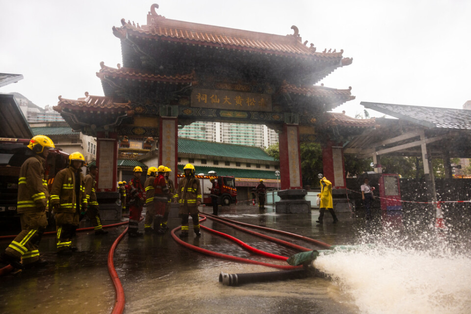 Brandmän dränerar bort regnvatten i Hongkong på fredagen.