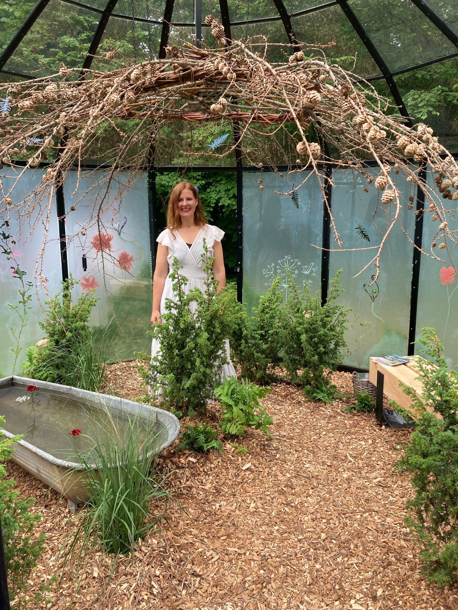 Underbar doft av eneflis möter besökaren! Trädgårdskreatören Kajsa Vildängens vitmålade glaspartier skapade ett hemligt, förtroligt växthus.