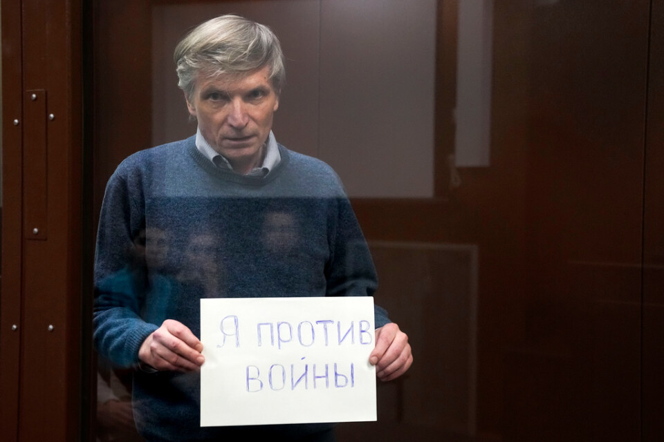 Aleksej Gorinov, som i juli dömdes till sju års fängelse, håller i rätten en skylt med texten "Jag är mot kriget".