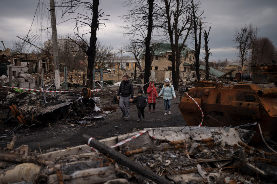 En familj på vandring i förödelsen i Butja strax utanför Kiev i Ukraina.
