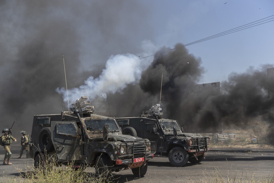 Israeliska militärfordon avfyrar tårgasbehållare mot palestinska demonstranter utanför Ramallah på Västbanken.