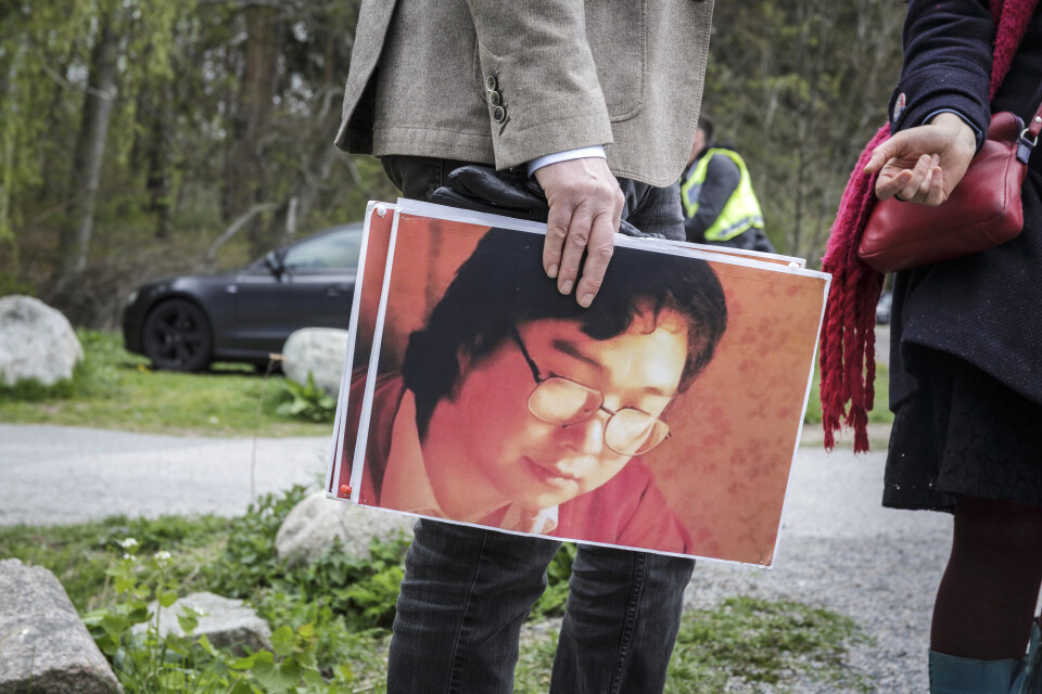 En person håller en bild av bokförläggaren Gui Minhai under en stödmanifestation utanför Kinas ambassad tidigare i maj.