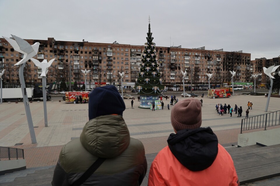 Mariupolbor vid ett torg med en julgran som pyntats för den ryskortodoxa julen på torsdagen.