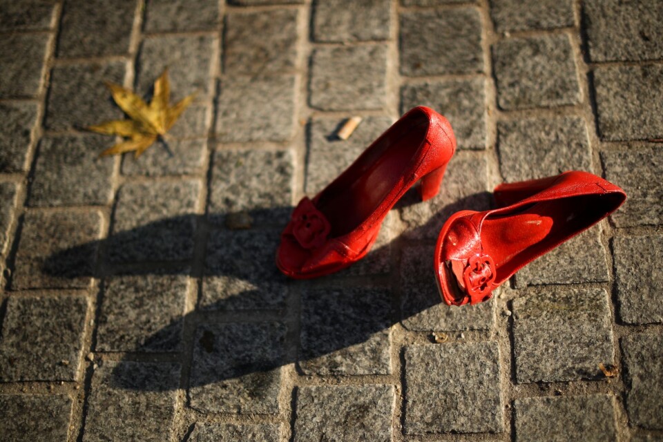 A pair of shoes lies on the ground among with other dozens of red painted shoes as a part of an installation against violence against women in Brussels, Monday, Nov. 25, 2019. (AP Photo/Francisco Seco)