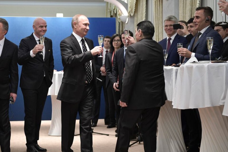Skål och välkommen! Rysslands president Vladimir Putin har Fifa-ordföranden Gianni Infantino till vänster om sig när han under VM-lottningen i Moskva höjde champagneglaset med den argentinske legenden Diego Maradona.