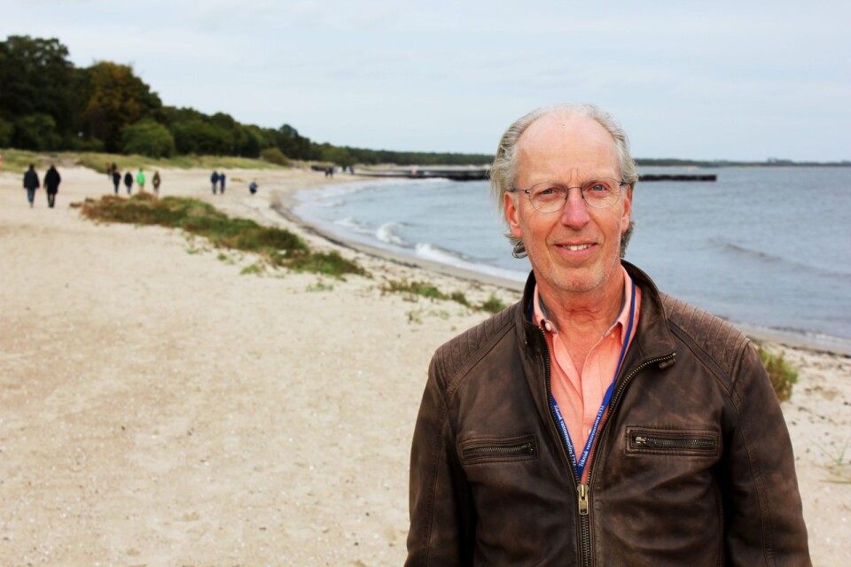 Hans Hanson får ibland glada hejjarop från Ystadsbor när han går längs med stränderna för sitt arbete med sanden.