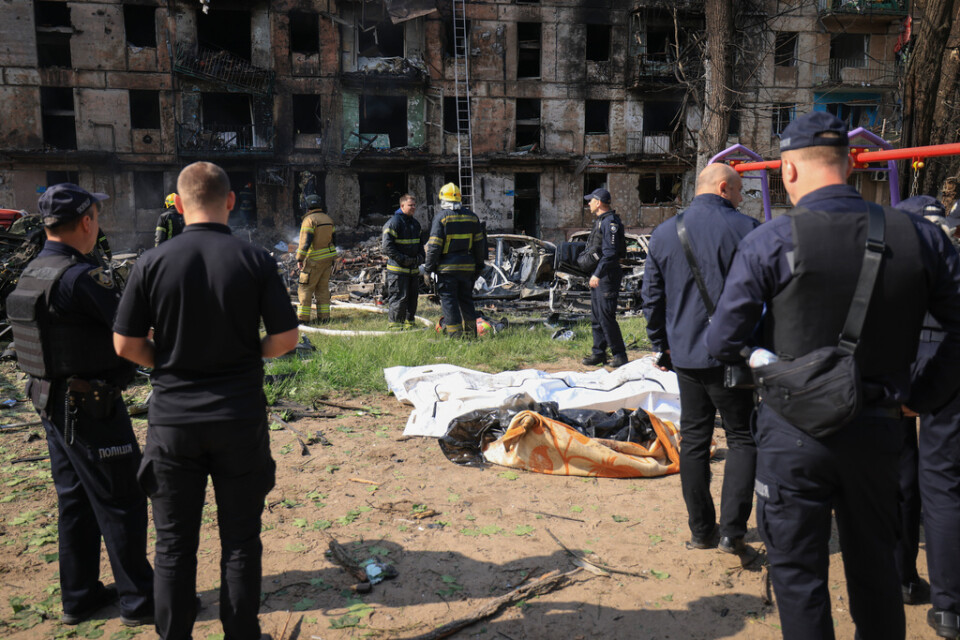 Ett flerfamiljshus med fem våningar träffades i ett ryskt robotanfall i natt. Civila personer som dödades har här radats upp på marken.